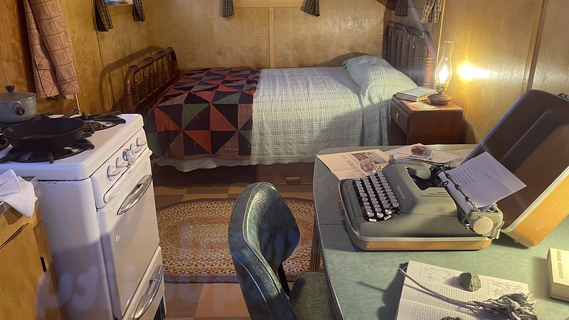 early 1900s cabin interior with a typewriter and writing desk.